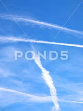 Blue sky and white contrails left by airliners or are chemtrails according to Stock Photos