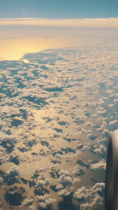 Blue Sky and white fluffy Clouds View from above through airplane's window at Stock Footage 305699057