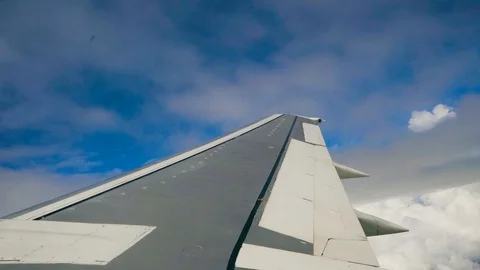 Blue sky and white heap clouds looking through porthole of flying airplane 4k Stock Footage 107743432