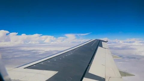 Blue sky and white heap clouds looking through porthole of flying airplane 4k Stock Footage 107744084