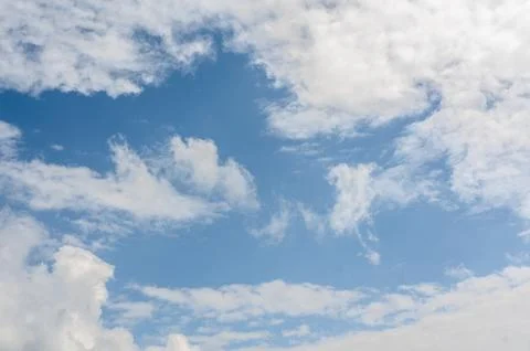 Blue sky backdrop adorned with fluffy white clouds sets serene and open can.. Stock Photos