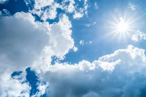 Blue sky background with clouds and sun. Stock Photos