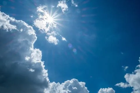 Blue sky background with clouds and sun. Stock Photos
