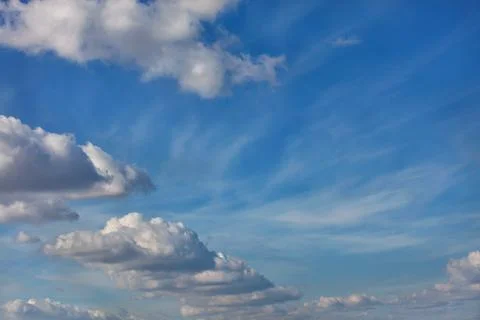 A blue sky background with a texture of white fluffy clouds Stock Photos