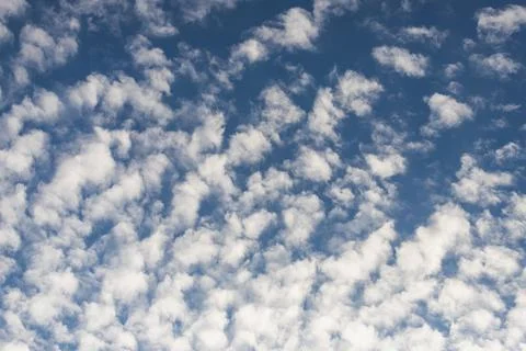 Blue sky background with tiny sunset clouds  in summer season. Cloud texture Stock Photos