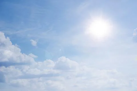 Blue sky background with white clouds concept. The sun shines in a starry sky Stock Photos