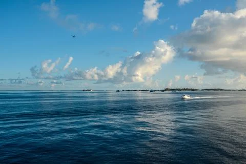 Blue sky, beautiful clouds, blue ocean, small island, sea plane in the sky, s Stock Photos