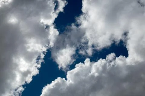 Blue sky between sunlit clouds Stock Photos