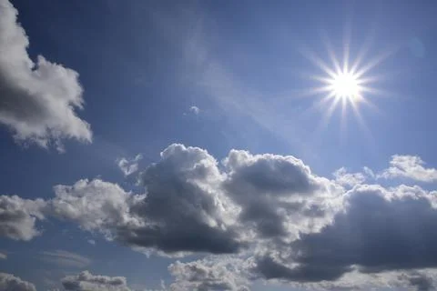 Blue sky, bright sun disc and white clouds. A wonderful panorama of summer sk Stock Photos
