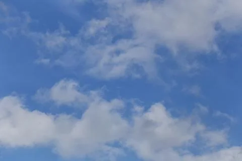 Blue sky with bright white clouds in daylight. Stock Photos