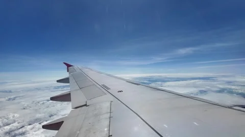 Blue sky with cloud, view from side window of plane. Stockbeeldmateriaal 311492575
