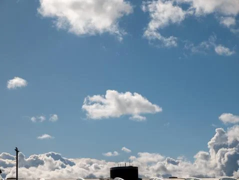 Blue Sky with Clouds Above Rooftops Stockfoto's