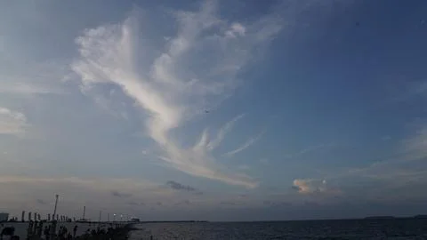 Blue Sky with Clouds and Distant Airplane Over the Sea Stockfoto's