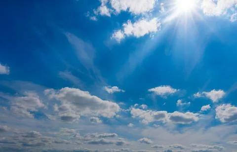 Blue sky with clouds and sun shines Stock Photos