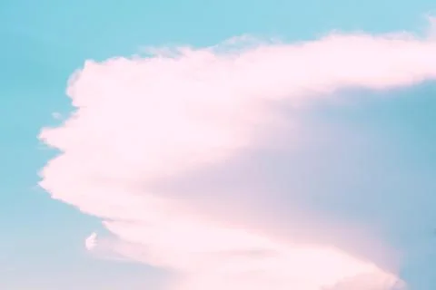 Blue sky with clouds in the form of pink streaks. Concept landscape, abstraction Stock Photos