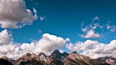 Blue sky with clouds over the mountains peaks Stock Photos