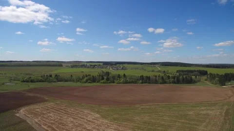 Blue sky with clouds, plowed field and a green forest. 스톡 동영상 63570926