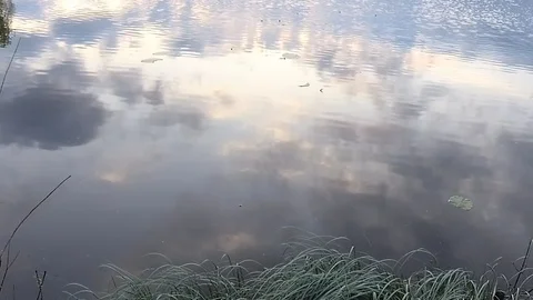 Blue sky with clouds reflected in the lake at sunset Video stock 108025182