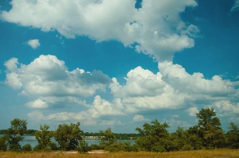 Blue sky with clouds, river and trees on the riverbank. Foto stock