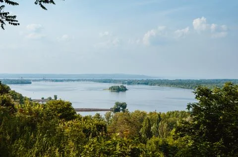 Blue sky with clouds, river and trees on the riverbank. Foto stock