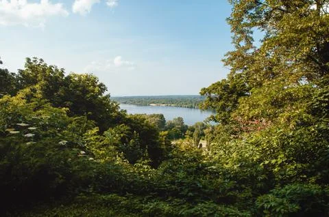 Blue sky with clouds, river and trees on the riverbank. Foto stock
