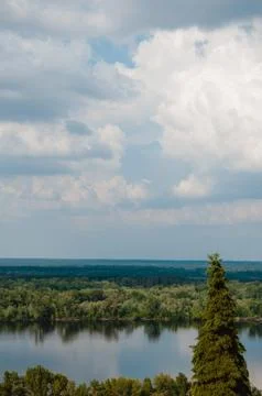 Blue sky with clouds, river and trees on the riverbank. Stock Photos