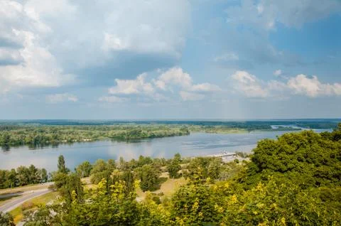 Blue sky with clouds, river and trees on the riverbank. Foto stock
