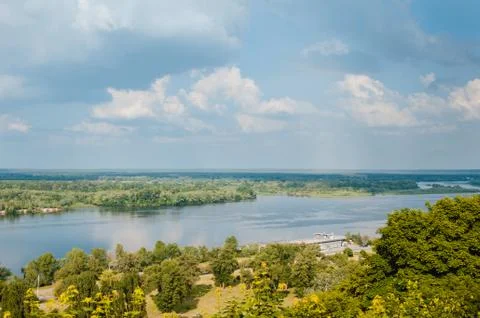 Blue sky with clouds, river and trees on the riverbank. Foto stock