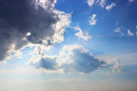 Blue sky with clouds, the sun is covered by dark clouds Stock Photos