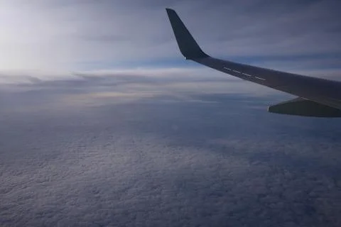 Blue sky, clouds view from an illuminator with a wing Фото