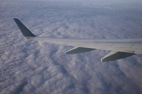 Blue sky, clouds view from an illuminator with a wing turns Stock Photos