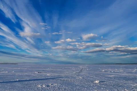 Blue sky with clouds on a winter day over the ice of the river Stock Photos