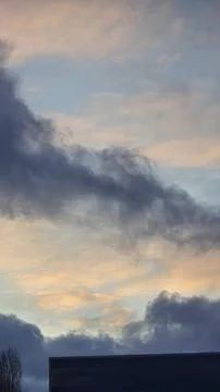 Blue sky with clouds, winter weather. Clouds on the background of trees. Фото