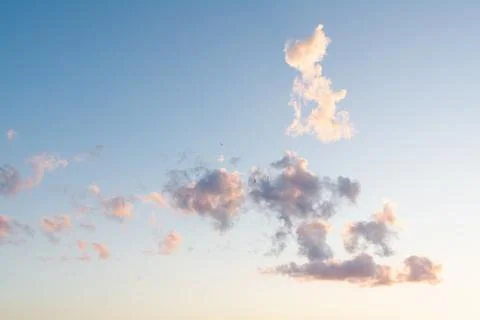 A blue sky with dark clouds above which a cloud flies in the form of a white  Stock Photos