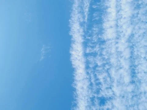 Blue sky divided by white clouds Stock Photos