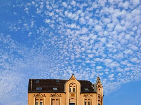 Blue Sky with Dramatic Altocumulus Cloudscape Above European Rooftop Stock Photos