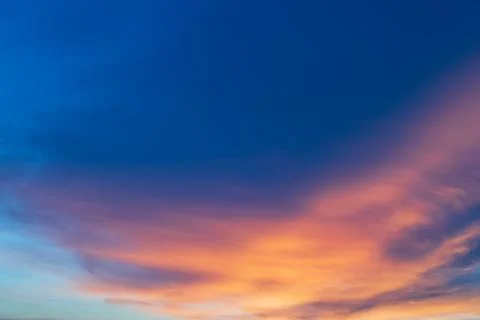 Blue sky with dramatic sunlit clouds. A blush appears. Stock Photos
