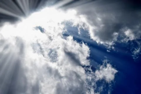The blue sky dramatically turns into heavy black clouds. Backlight sunlight. Stock Photos