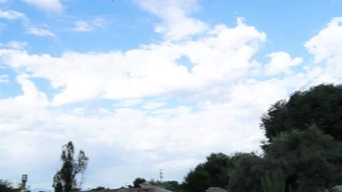 Blue sky with drifting clouds and rural horizon, wide landscape view Vidéo 312758118