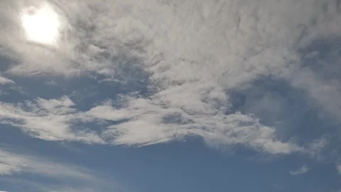 Blue Sky with Drifting White and Grey Clouds and Bright Sun Stock Footage 346140689