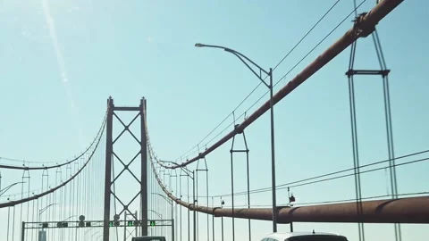 Blue sky driving windshield POV suspension bridge support cable structure Stock Footage 169285136