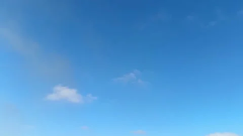 Blue sky with a few small, thin cumulus clouds drifting very slowly. Stock Footage 328079448