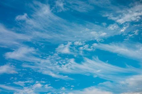 Blue sky filled with dynamic white clouds shaped by strong wind currents. 스톡 사진