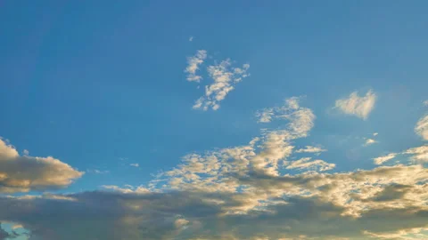 Blue sky with floating clouds illuminated by sun during sunset. Stock Footage 198211535