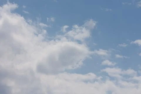 Blue sky with floating white clouds Stock Photos