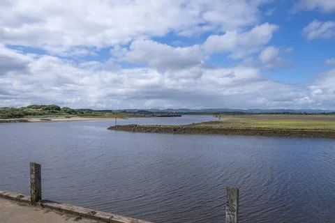 Blue sky with fluffy clouds above calm water Stock Photos