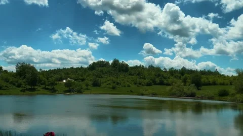 Blue sky, fluffy clouds, green hills, calm lake. Vrmdza Lake, Serbia Vídeos de archivo 338024970