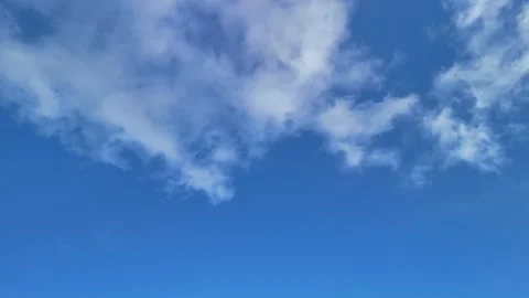 Blue sky with fluffy white clouds panning shot Stock Footage 303702657