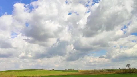 Blue Sky with Fluffy White Clouds Over Golden Rural Fields in Motion Stock Footage 327880740