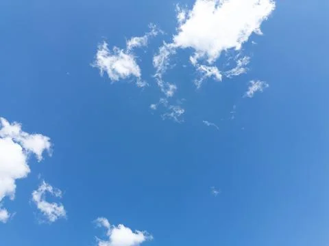 Blue sky with fluffy white clouds. Perfect summer day background image. Stock Photos
